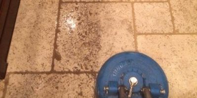 tile floor being cleaned with sweeper